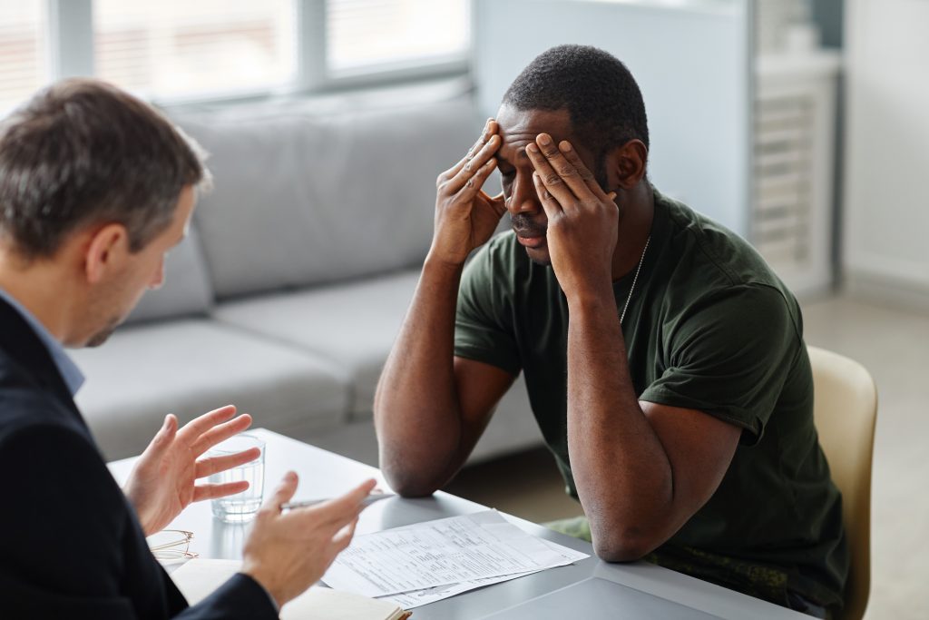 Man Suffering PTSD At Therapy Session